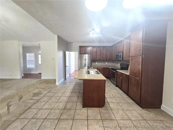 a kitchen with stainless steel appliances granite countertop a stove a sink and a refrigerator