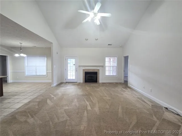 a view of an empty room with a fireplace and a window