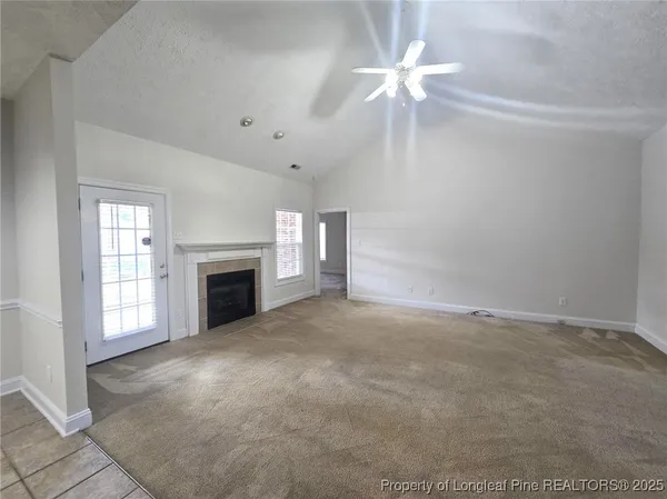 an empty room with fireplace and fan