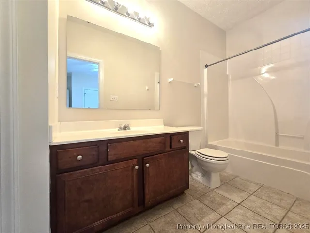 an empty room with a chandelier fan and windows