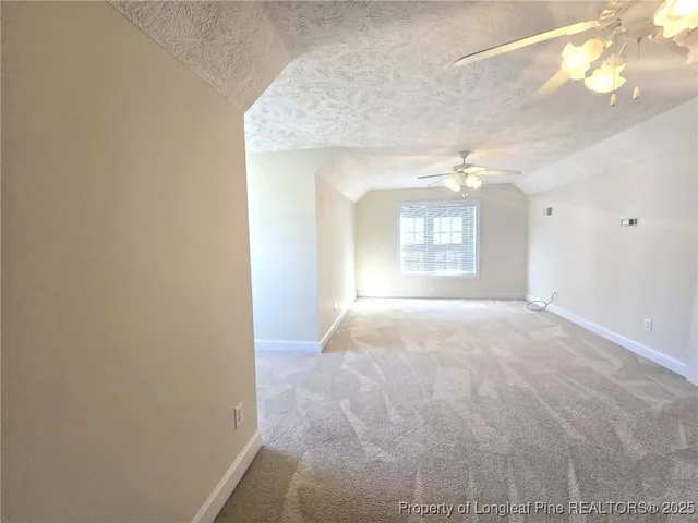 a view of a hallway with wooden floor and a window