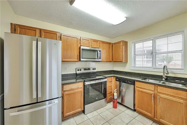 a kitchen with stainless steel appliances granite countertop a refrigerator sink and stove
