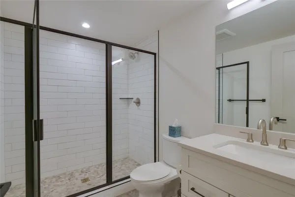 a bathroom with a sink a toilet and shower