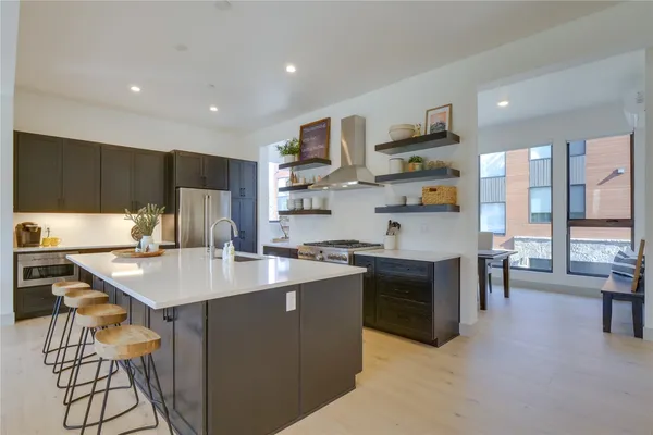 a kitchen with stainless steel appliances granite countertop a sink a stove and a refrigerator