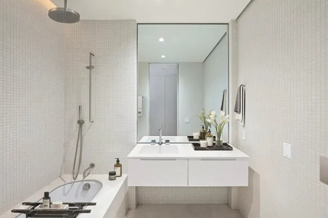 a bathroom with a tub sink and mirror