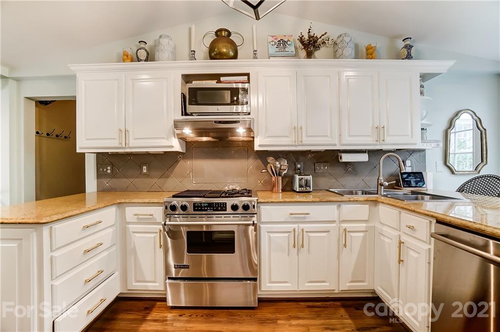2610 Providence Road Charlotte, NC 28211 - Photo 7 of 37 a white kitchen with granite countertop stainless steel appliances and white cabinets