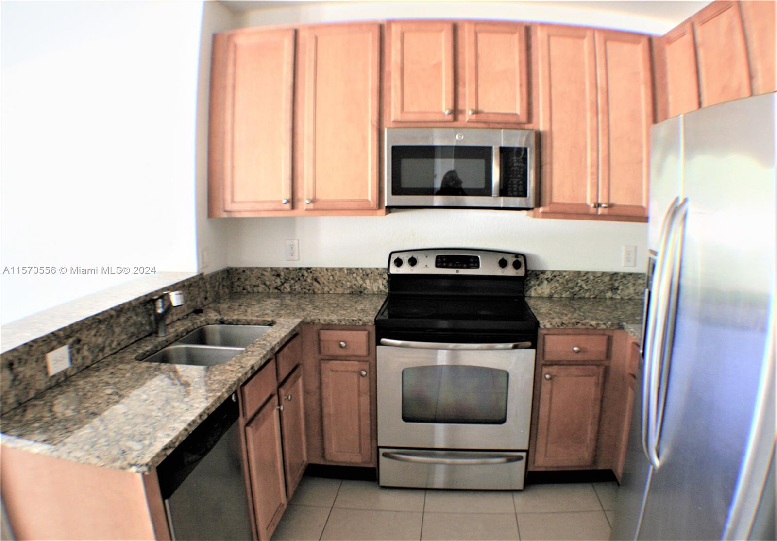 202 Las Brisas Circle Sunrise, FL 33326 - Photo 3 of 12 a kitchen with granite countertop a sink and a stove