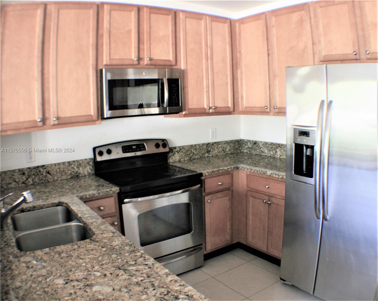 202 Las Brisas Circle Sunrise, FL 33326 - Photo 5 of 12 a kitchen with stainless steel appliances granite countertop a sink stove and microwave