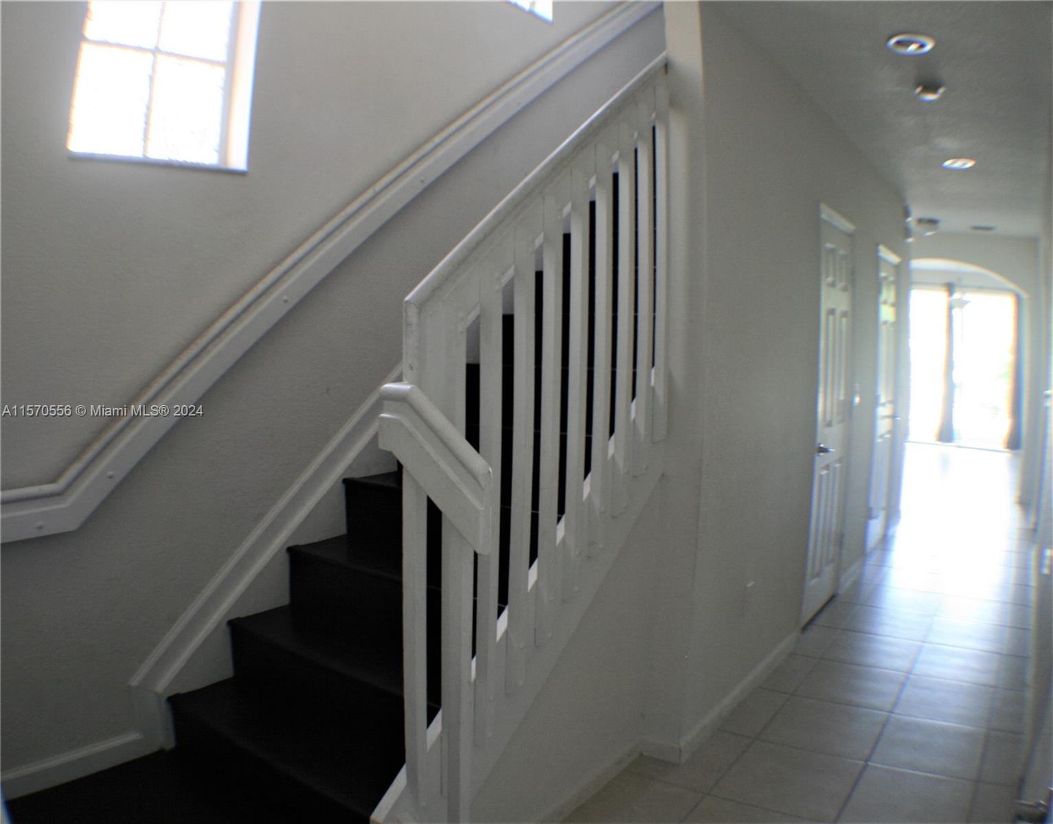 202 Las Brisas Circle Sunrise, FL 33326 - Photo 6 of 12 a view of staircase with lots of frames on wall and windows