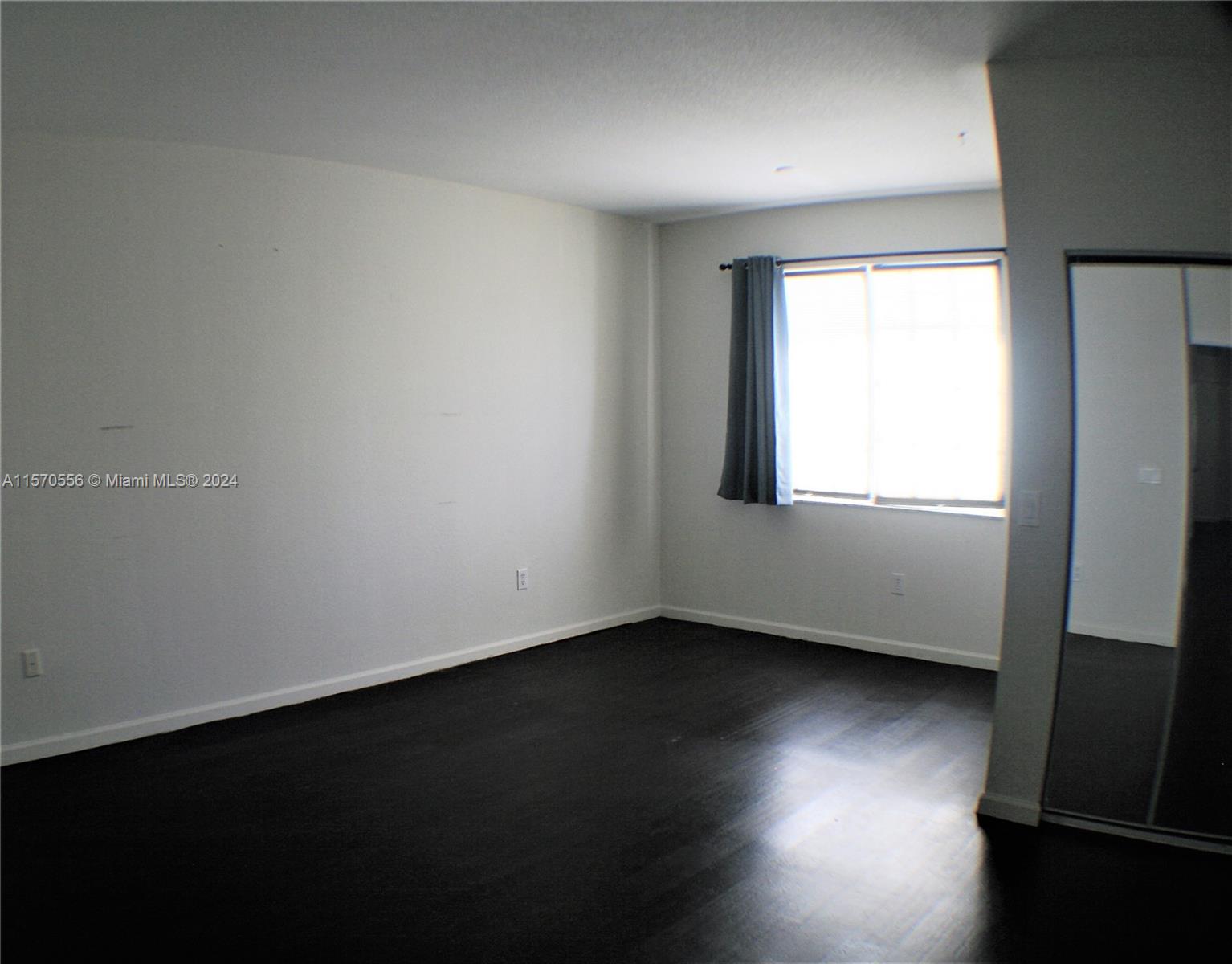 202 Las Brisas Circle Sunrise, FL 33326 - Photo 7 of 12 an empty room with wooden floor and windows