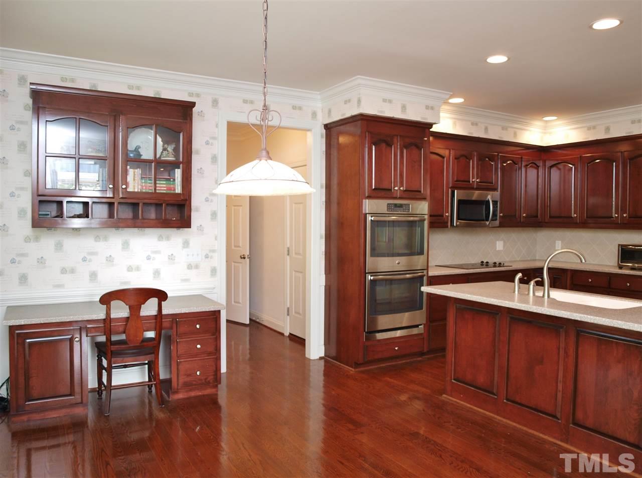 3317 La Costa Way Raleigh, NC 27610 - Photo 5 of 25 a kitchen with granite countertop wooden floors and wooden cabinets