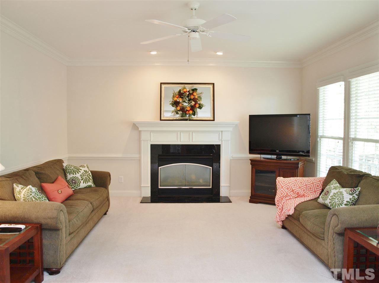 3317 La Costa Way Raleigh, NC 27610 - Photo 7 of 25 a living room with furniture a flat screen tv and a fireplace