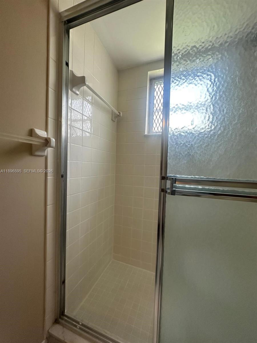9848 Marina Boulevard, Unit 811 Boca Raton, FL 33428 - Photo 46 of 86 a bathroom with a glass shower door