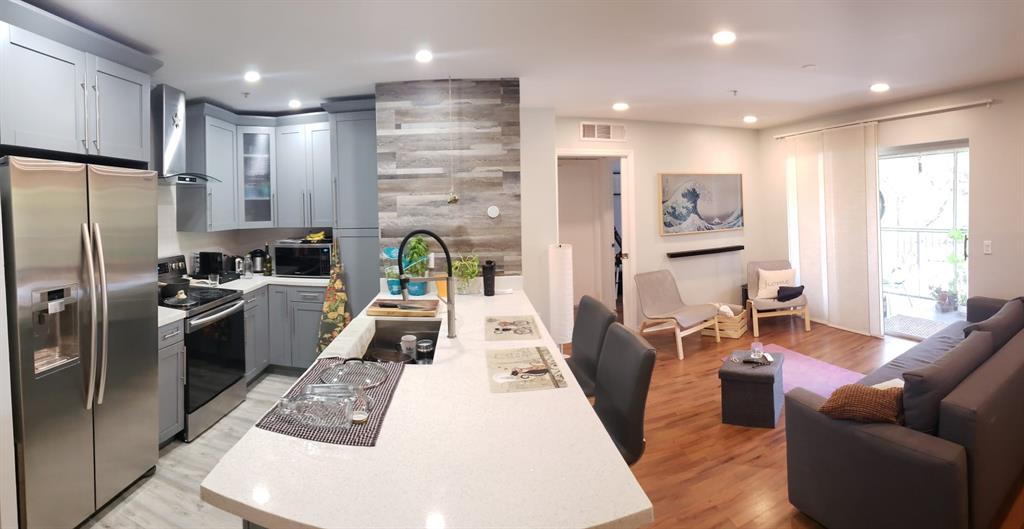 a kitchen with stainless steel appliances granite countertop a refrigerator sink and stove