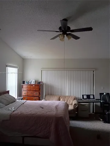 a bedroom with a bed and a ceiling fan