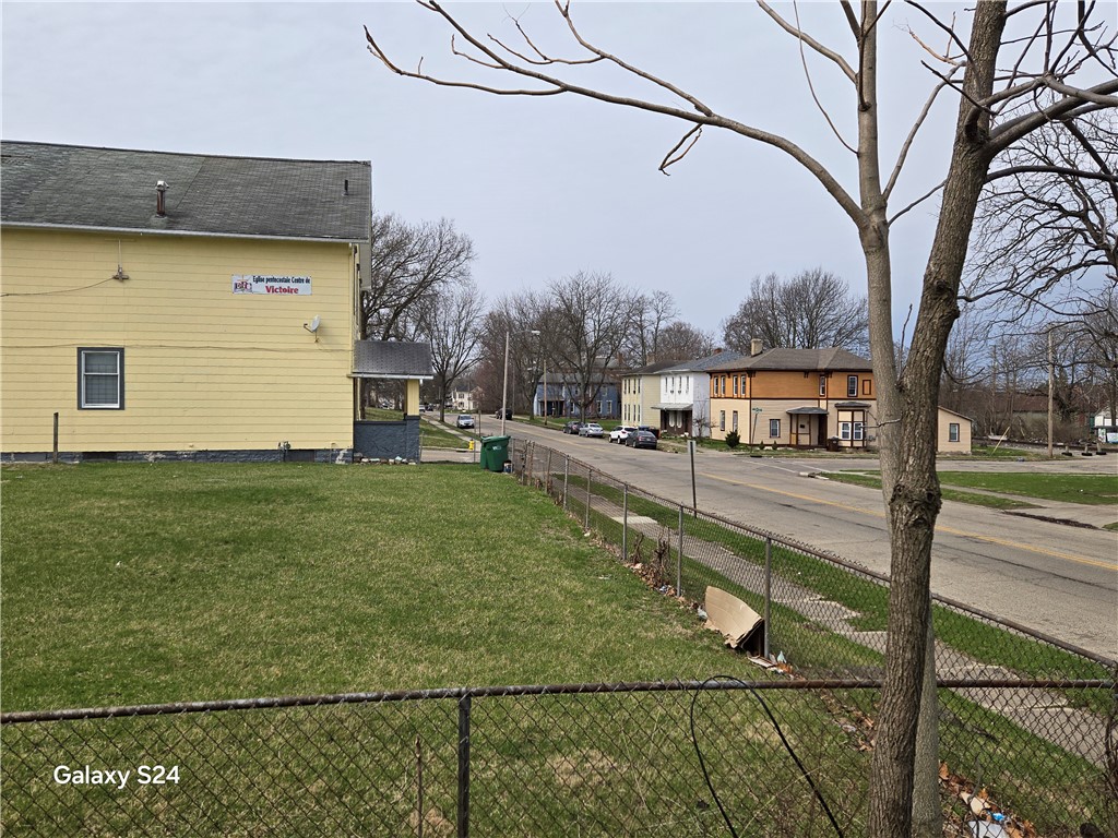 727 West High Street Springfield, OH 45506 - Photo 24 of 29 This residential property offers a well-maintained lawn and a practical chain-link fence, ready for new occupants.