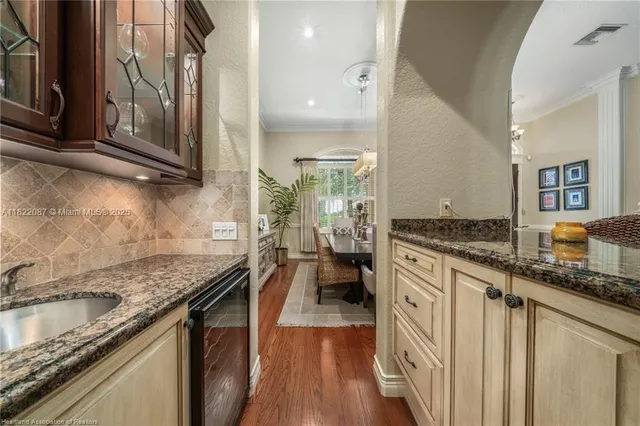 a dining room with furniture a large window and wooden floor