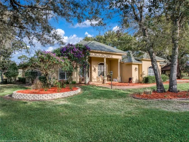 a front view of a house with a yard and trees
