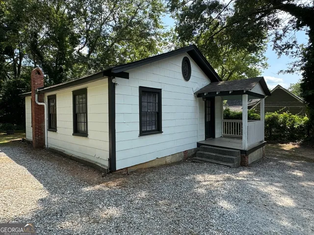 a view of a house with a yard and wooden fence