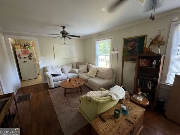 a living room with furniture a ceiling fan and a rug
