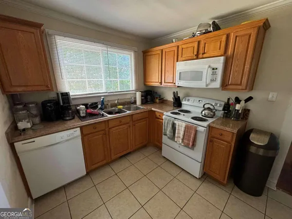 a kitchen with a sink a stove cabinets and a window