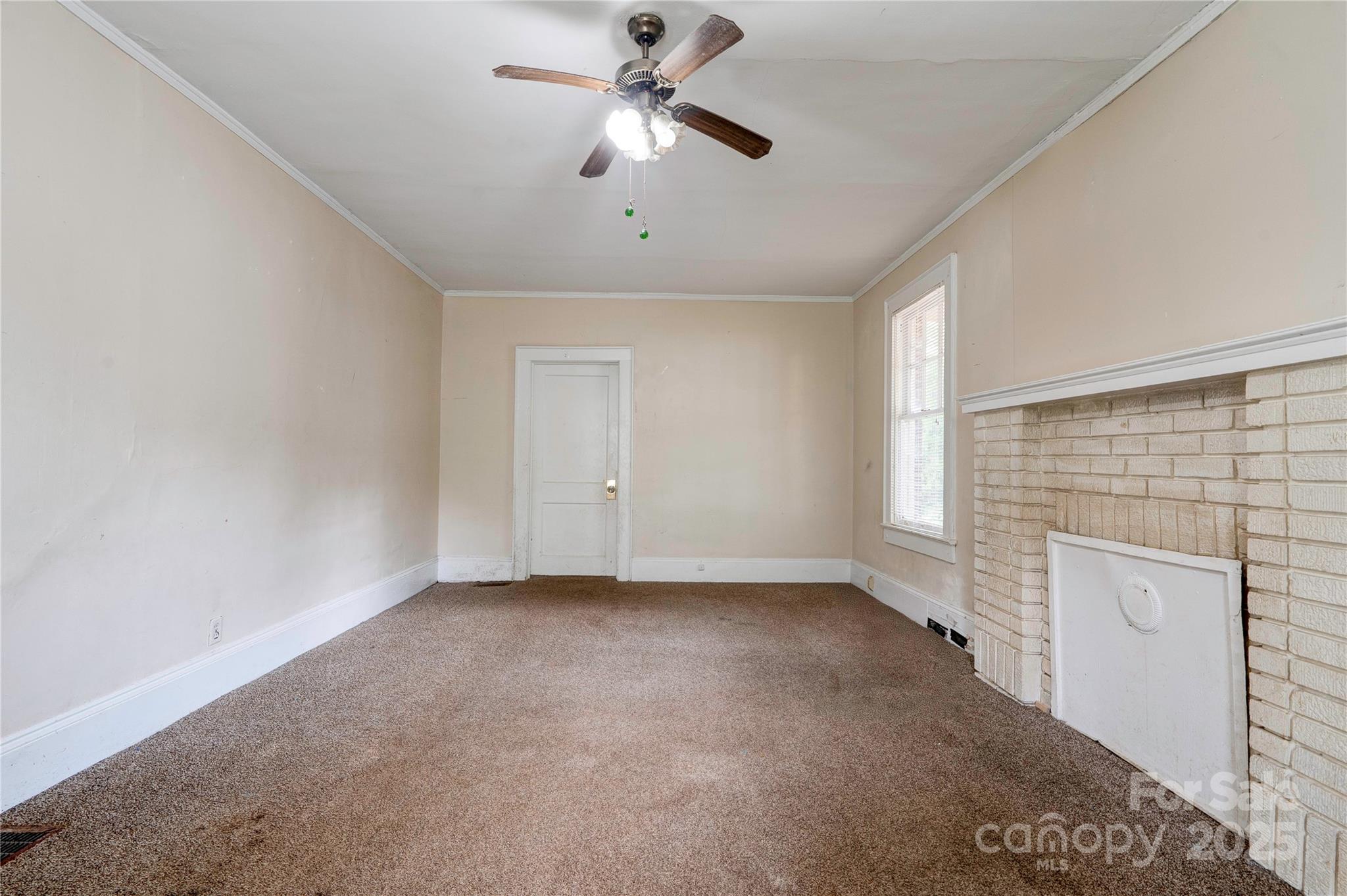 1521 Kings Road Shelby, NC 28150 - Photo 13 of 38 a view of a livingroom with a ceiling fan a fireplace and windows