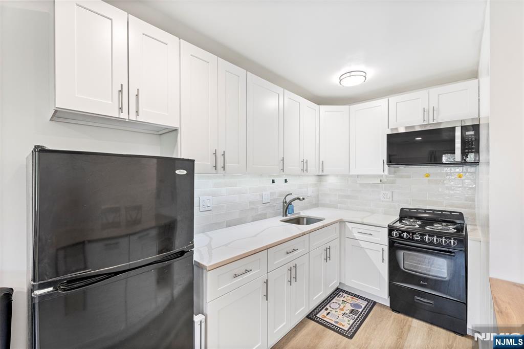 9 Vreeland Avenue, Unit 3A Hackensack, NJ 07601 - Photo 1 of 24 a kitchen with granite countertop a refrigerator stove and microwave