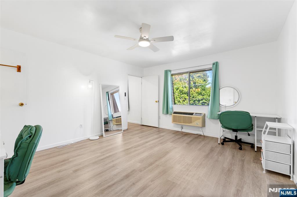 9 Vreeland Avenue, Unit 3A Hackensack, NJ 07601 - Photo 8 of 24 a view of an empty room with wooden floor and a window