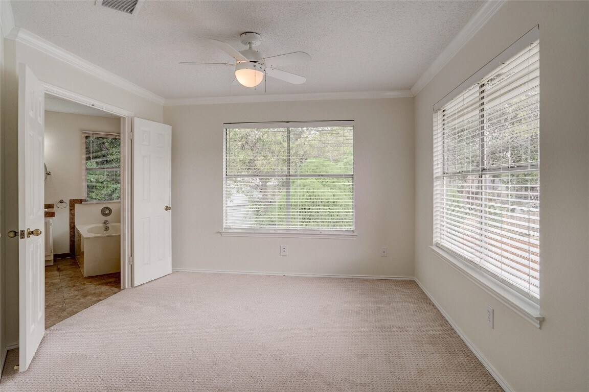 7604 Napier Trail Austin, TX 78729 - Photo 16 of 27 an empty room with windows and a bed