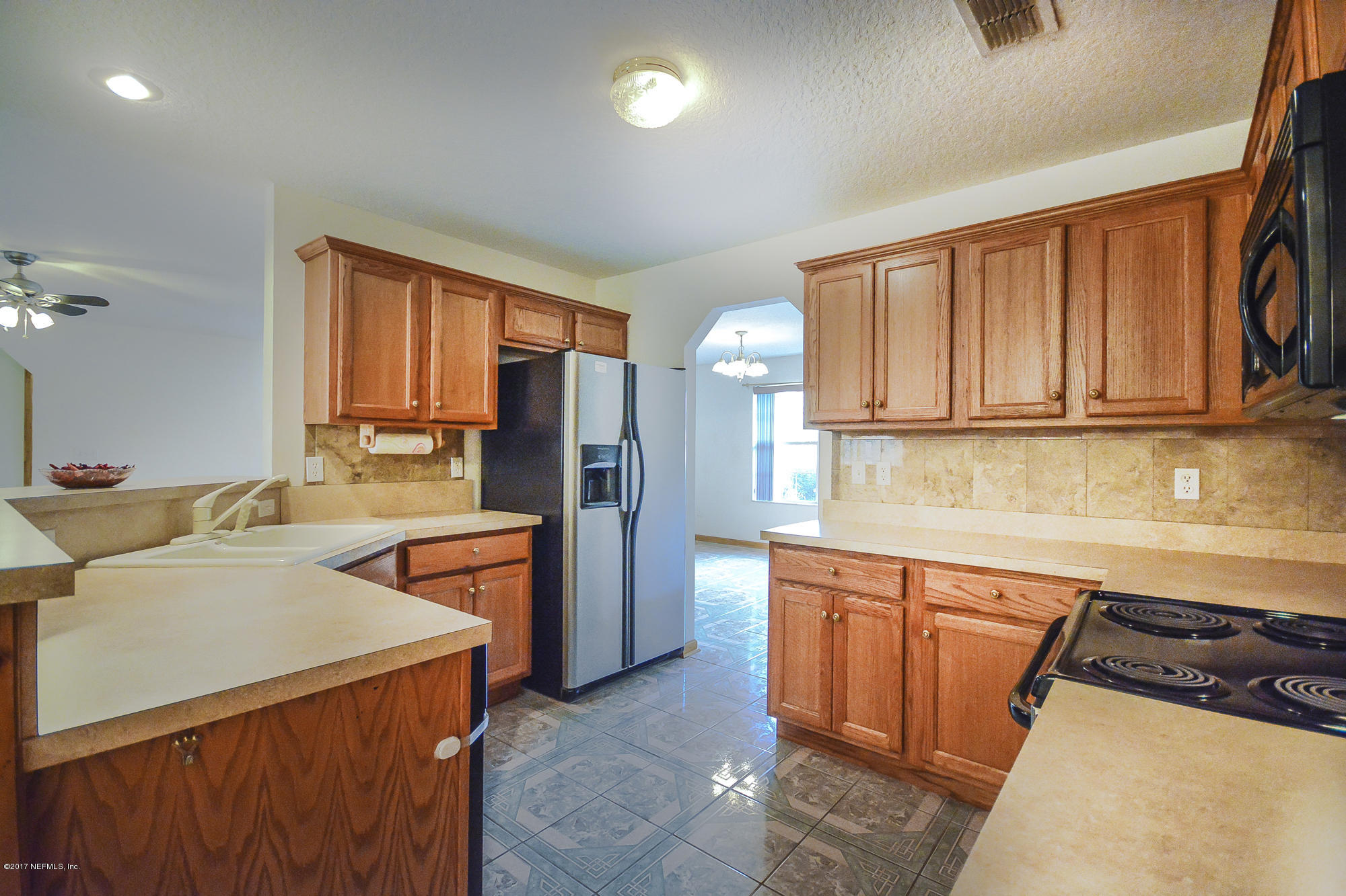 4822 Ricker Road Jacksonville, FL 32210 - Photo 18 of 50 a kitchen with stainless steel appliances granite countertop a refrigerator stove and sink