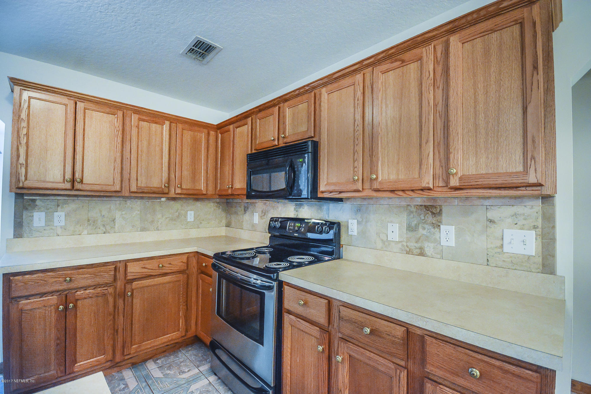 4822 Ricker Road Jacksonville, FL 32210 - Photo 19 of 50 a kitchen with stainless steel appliances granite countertop a sink dishwasher stove and cabinets with wooden floor