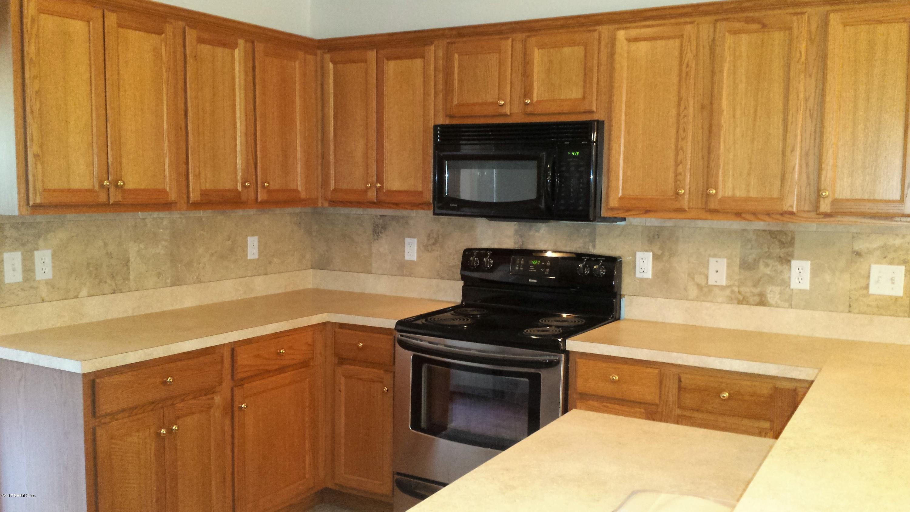 4822 Ricker Road Jacksonville, FL 32210 - Photo 20 of 50 a kitchen with granite countertop a stove top oven a sink dishwasher and granite countertops
