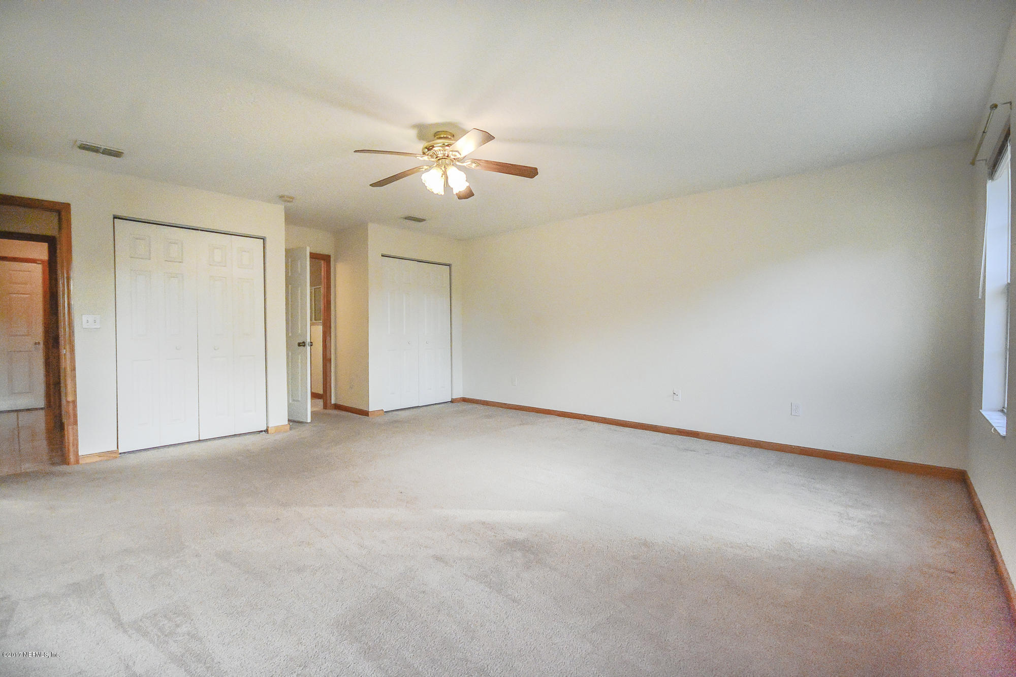 4822 Ricker Road Jacksonville, FL 32210 - Photo 23 of 50 an empty room with a window and a ceiling fan