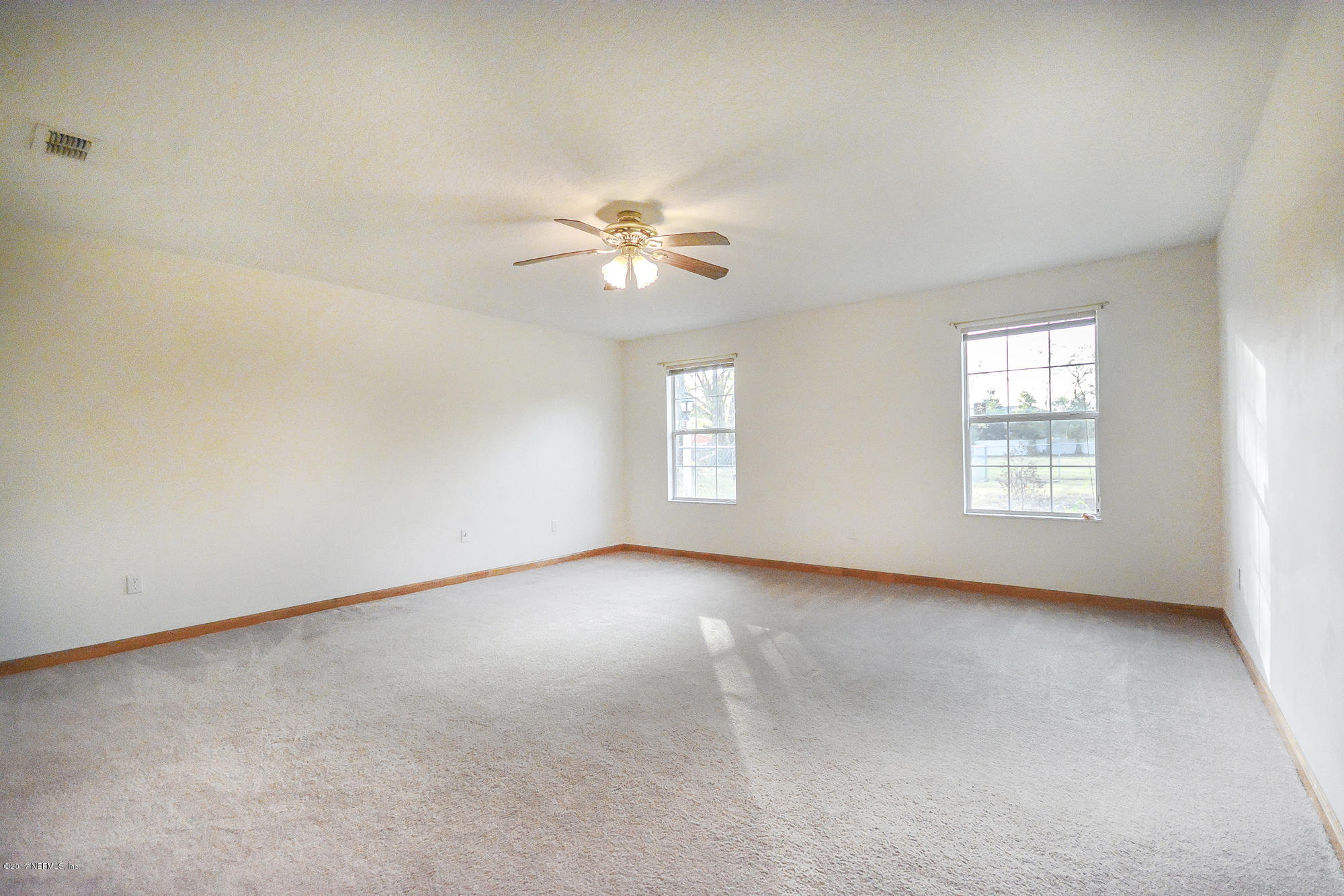 4822 Ricker Road Jacksonville, FL 32210 - Photo 24 of 50 an empty room with windows and ceiling fan