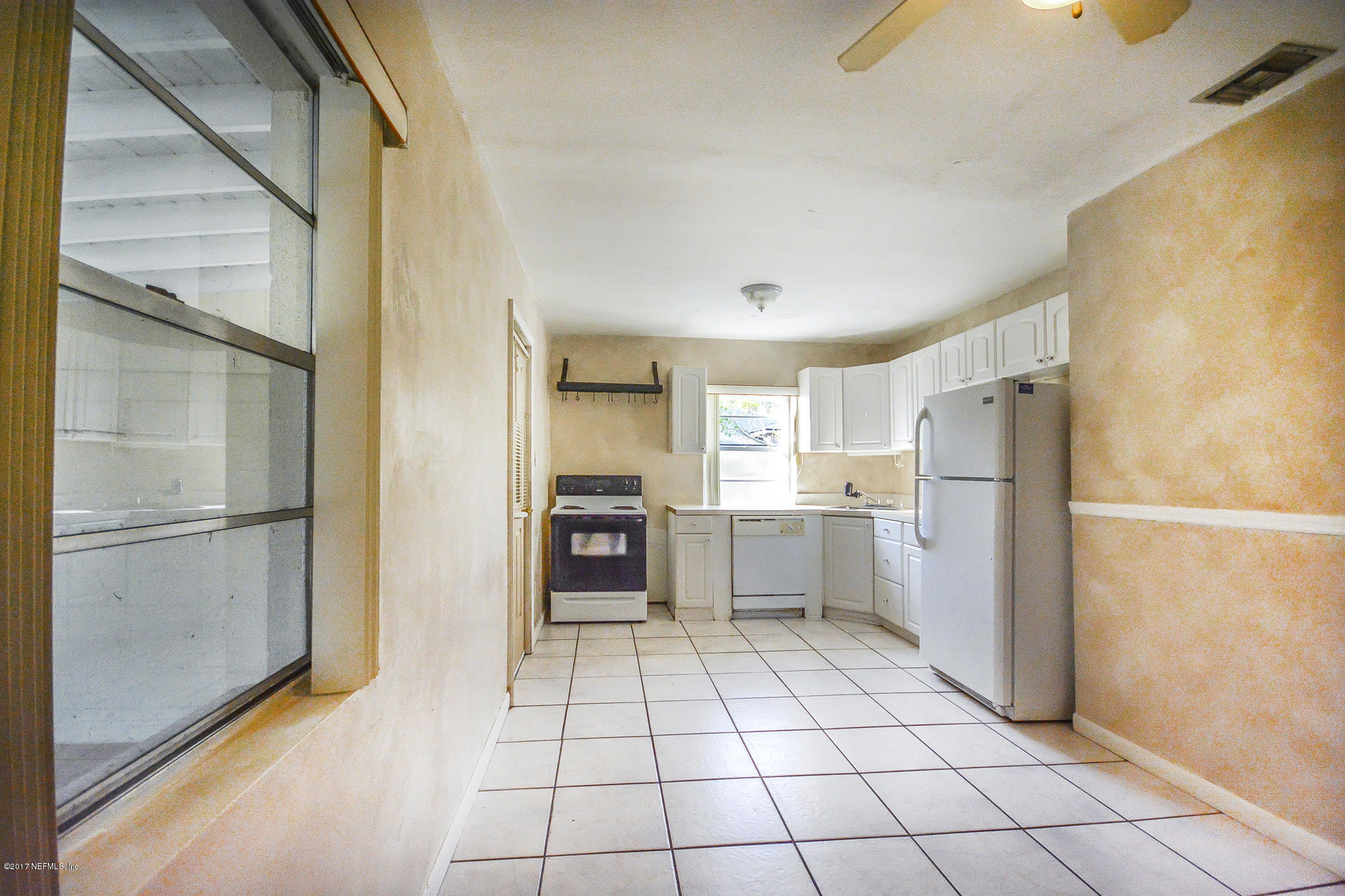 4822 Ricker Road Jacksonville, FL 32210 - Photo 40 of 50 a kitchen with a refrigerator a sink and a stove top oven