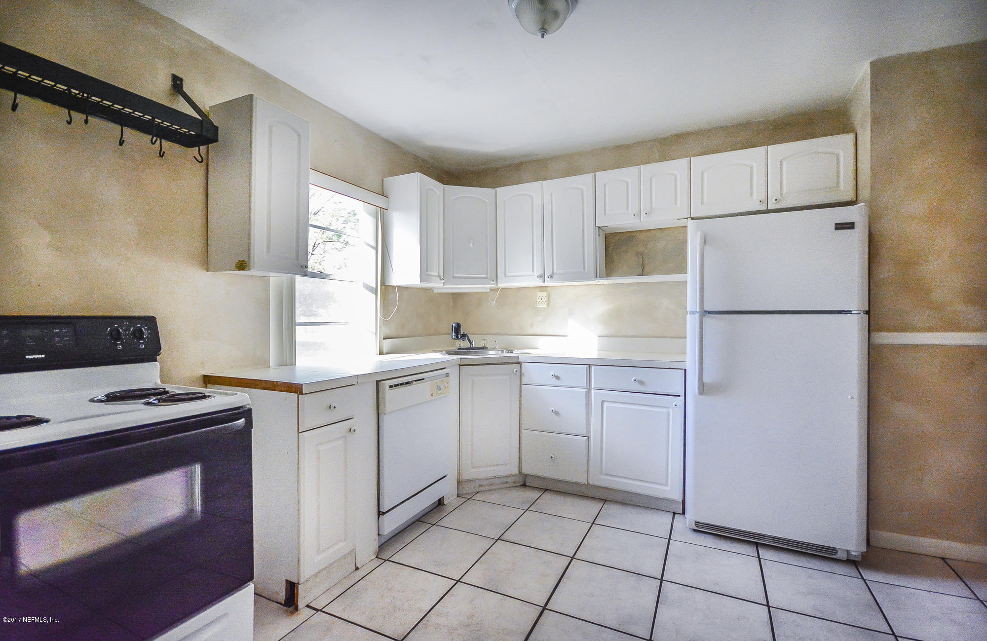 4822 Ricker Road Jacksonville, FL 32210 - Photo 41 of 50 a kitchen with a refrigerator sink and cabinets