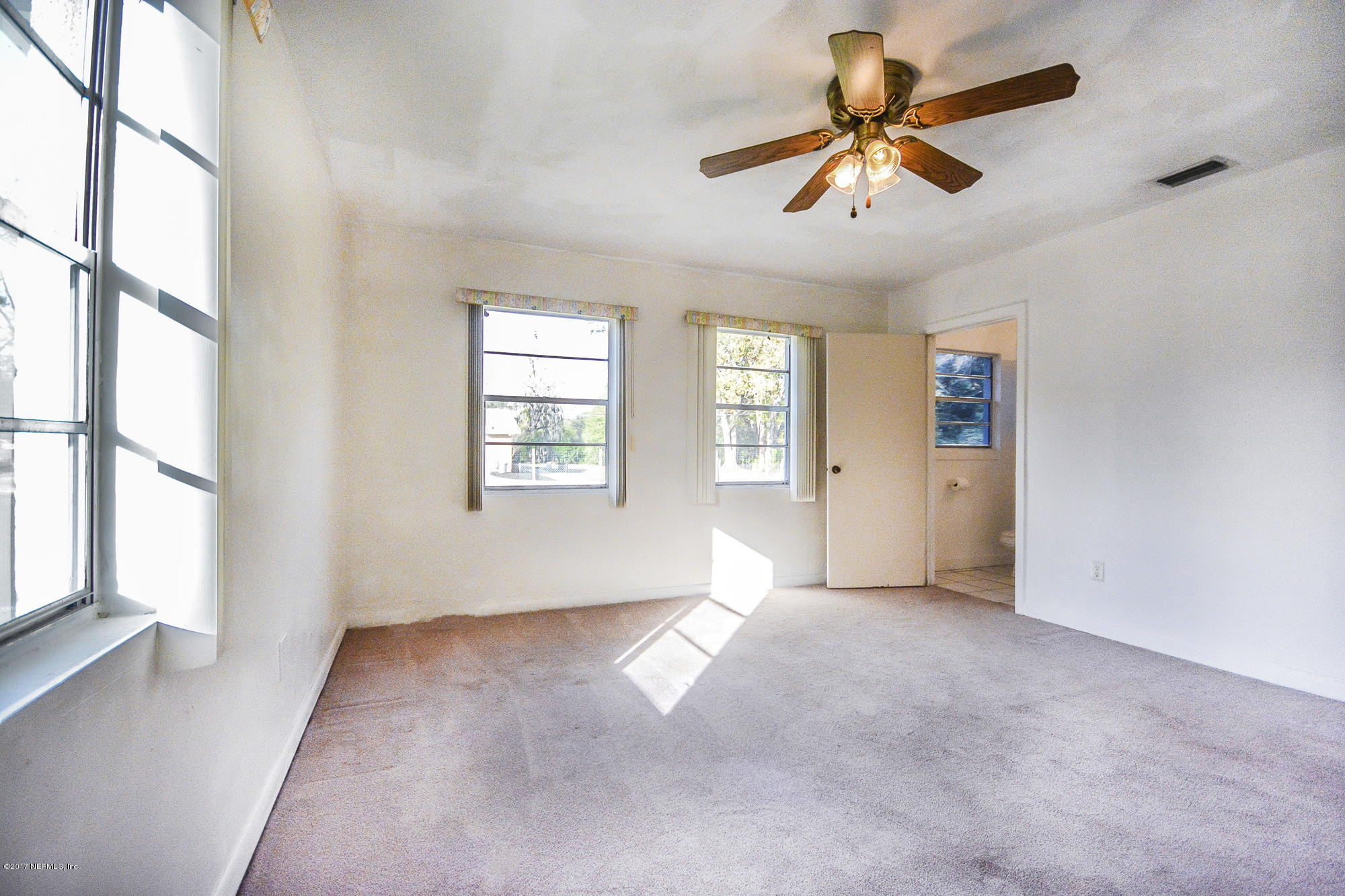 4822 Ricker Road Jacksonville, FL 32210 - Photo 46 of 50 wooden floor in an empty room with a window
