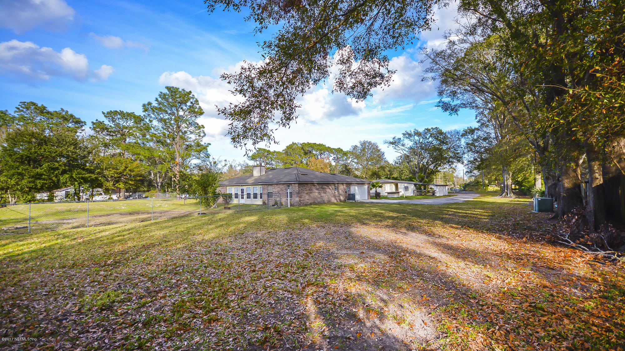 4822 Ricker Road Jacksonville, FL 32210 - Photo 50 of 50 a view of big yard next to a house with large trees