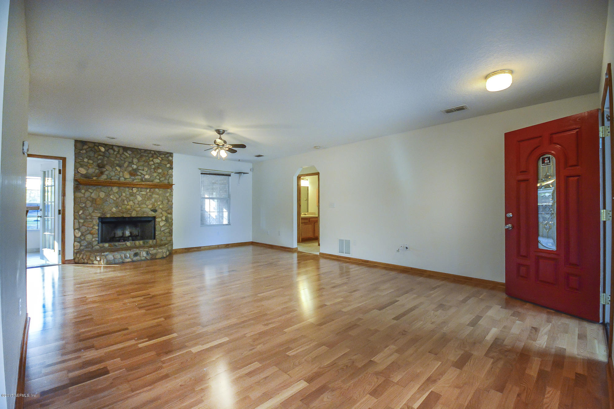4822 Ricker Road Jacksonville, FL 32210 - Photo 9 of 50 a view of an empty room with window and wooden floor