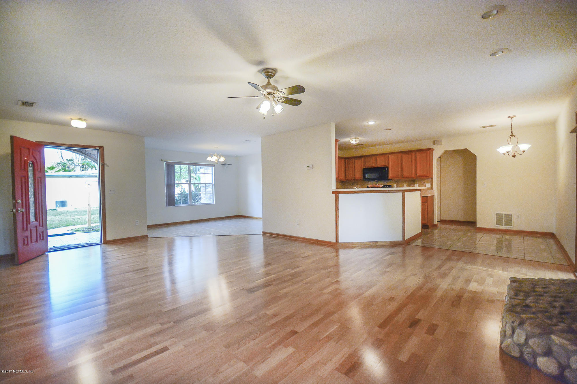 4822 Ricker Road Jacksonville, FL 32210 - Photo 10 of 50 a view of an empty room with window and wooden floor
