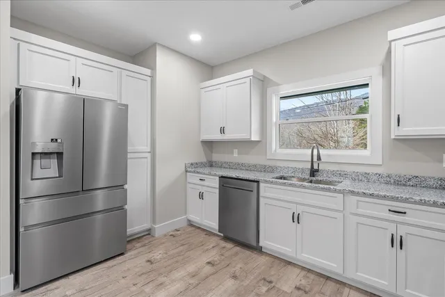 a kitchen with stainless steel appliances granite countertop a refrigerator sink and cabinets