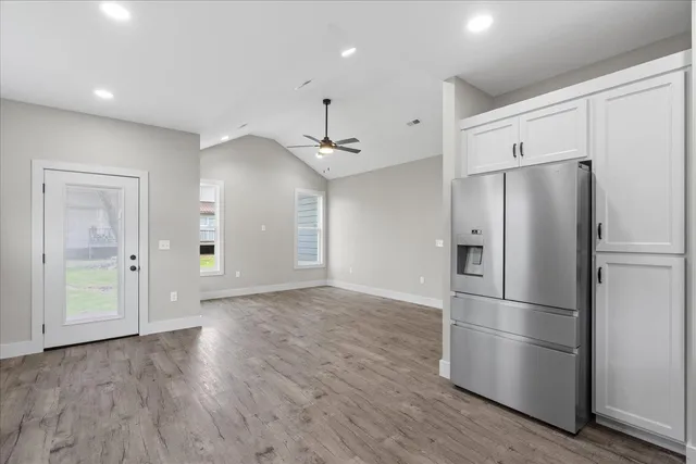 a kitchen with stainless steel appliances a refrigerator and wooden floor