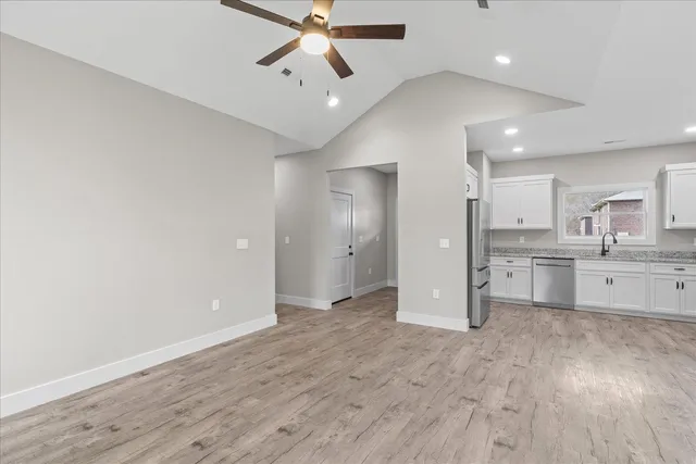 a view of a kitchen with wooden floor and a sink