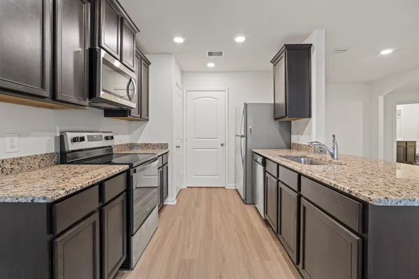 a kitchen with stainless steel appliances granite countertop a kitchen island hardwood floor sink stove and refrigerator