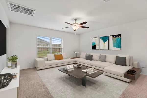 a living room with furniture ceiling fan and a window