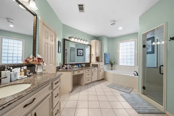 a large bathroom with a double vanity sink mirror and bathtub