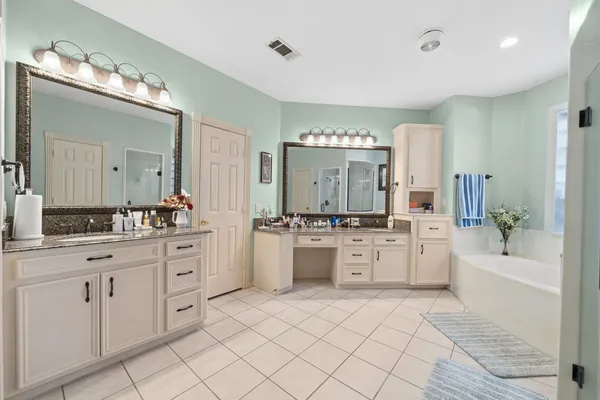 a bathroom with a bathtub a sink and a large mirror