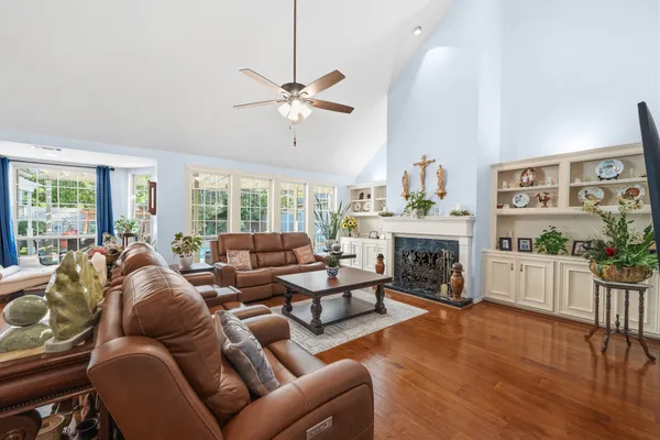 a living room with furniture a ceiling fan and a large window