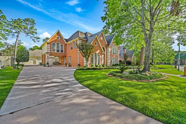 a front view of a house with yard and green space