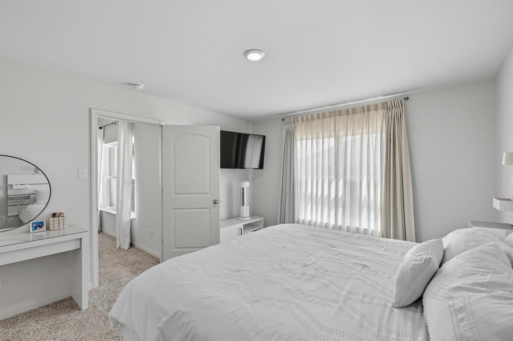 13511 Mineral Road Ponder, TX 76259 - Photo 25 of 40 a bedroom with a bed a mirror and a window